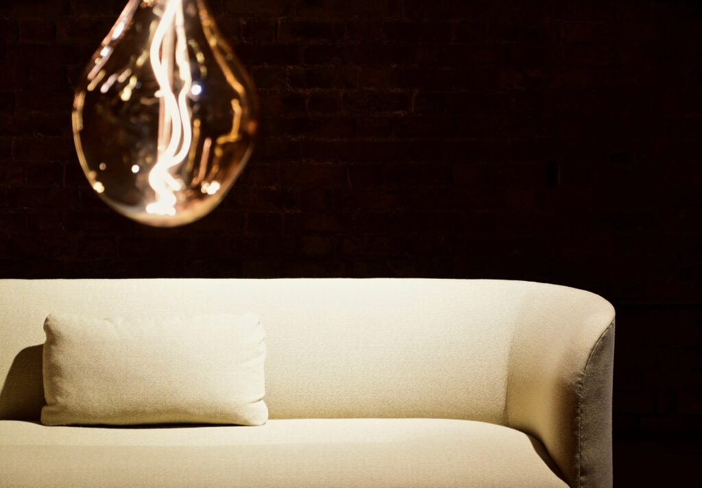 ampoule allumée suspendue au-dessus d'un canapé